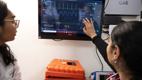 Students study a medial monitoring screen in a simulation lab
