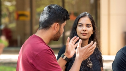 Rutgers students talk at a table outside on campus