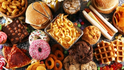 Overhead photo of junk food, like donuts, french fries, burgers, candy and more