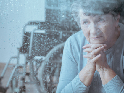 Older woman looks through rain-swept window