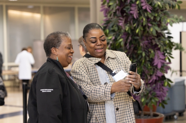 Two attendees talk and take a photo at the integration summit.