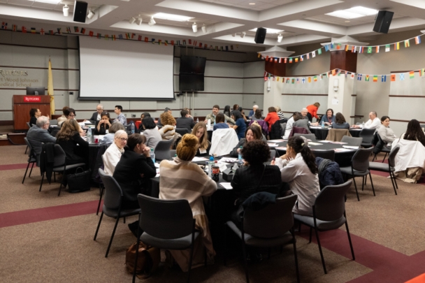 Faculty, staff, and students sit at tables at the integration summit at RWJMS.