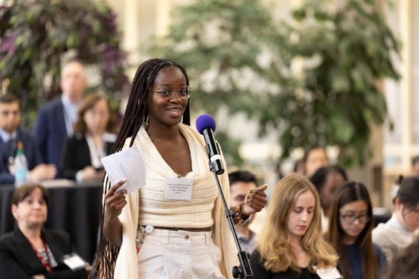 A student speaks into a microphone at the integration summit at RWJMS.